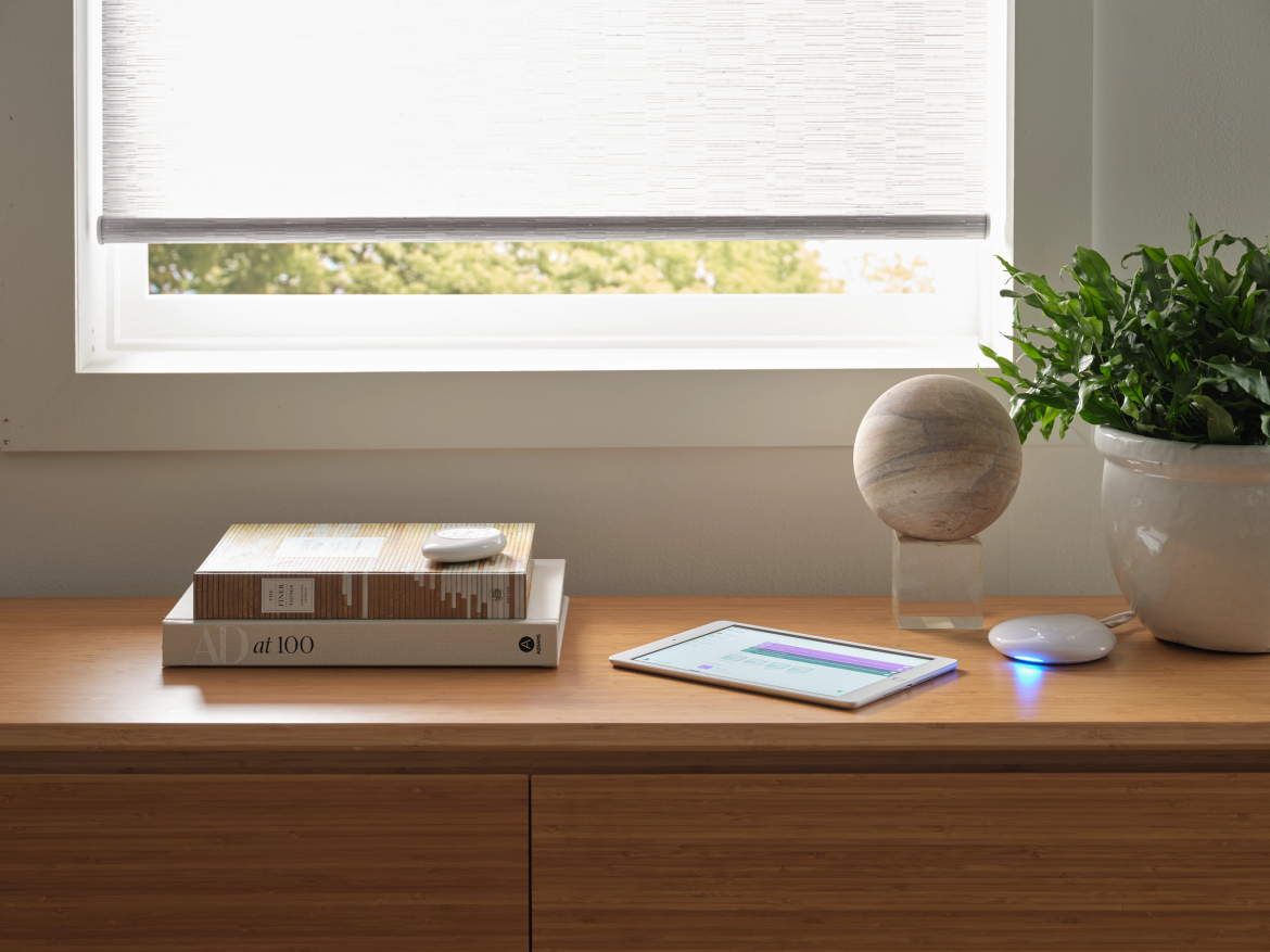 A desk with a book and a plant in a vase