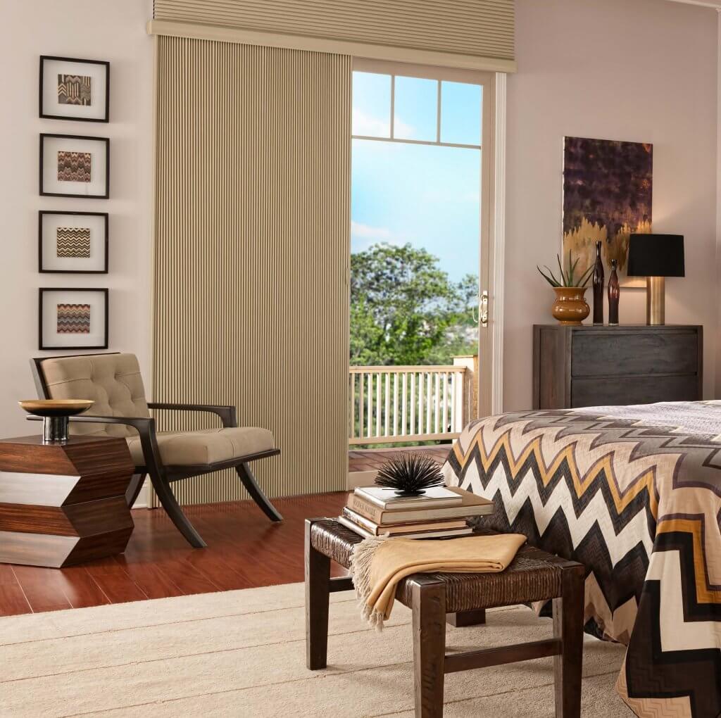 Bedroom furniture next to a balcony door with vertical blinds
