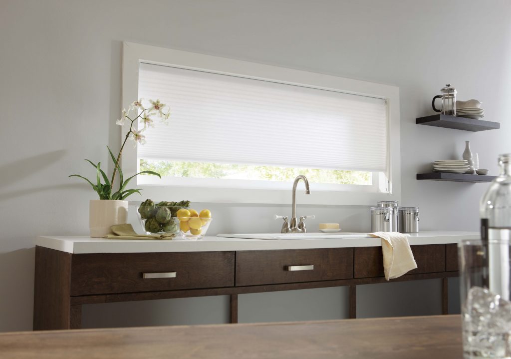 Kitchen sink in front of large window with motorized blinds